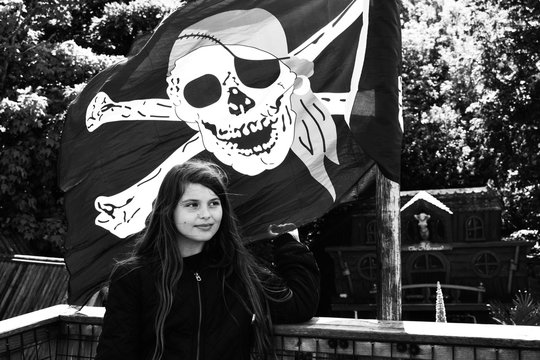 Girl Standing Against Pirate Flag
