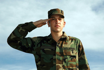 Young Soldier stands  at attention dressed in a USA military uniform 