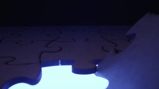 Jigsaw puzzle piece missing with light flashing through the open hole - symbolic element for Autism, business, problem solving, mystery and crime