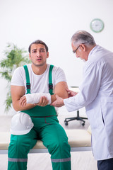 Obraz premium Young male contractor visiting old doctor