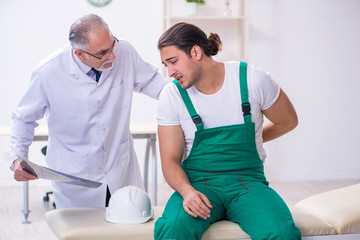 Obraz premium Young male contractor visiting old doctor