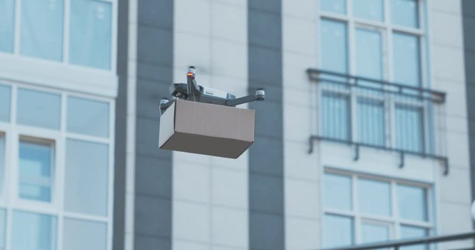 Drone landing with shipping box into female recipient hands