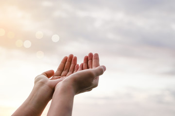 Woman hands place together like praying in front of nature green  background.