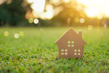 Closed up tiny home model on green grass with sunlight background.