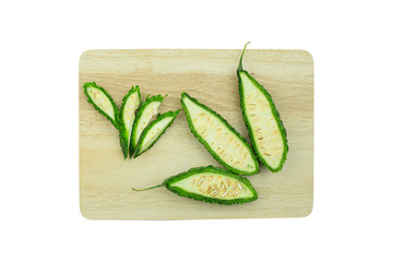 Bitter gourd placed on a chopping wooden board. Isolated on white background with clipping path and copy space.