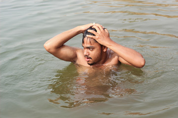 young man model bathing in a river