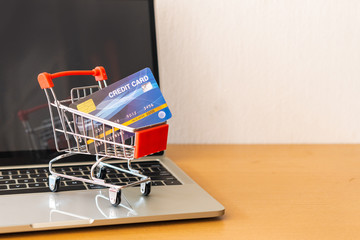 credit card and cart supermarket on wood table. shopping concept