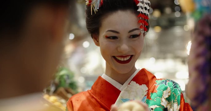Attractive japanese geishas in traditional dresses walking around modern city, talking and positively smiling - traditional culture in modern world 4k footage