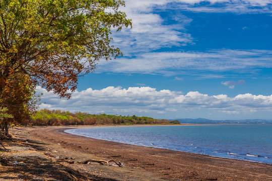 Deserted Lomolomo Beach, under a blue sky with clouds, Fiji.
