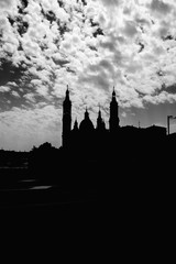 Silueta del Pilar, catedral de Zaragoza. Fotografia en blanco y negro con cielo soleado con nubes. 