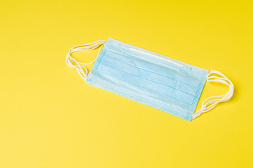 Medical or surgical face mask isolated on yellow background, coronavirus and infection protection.