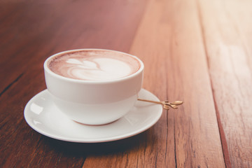 Latte art coffee on wood table.