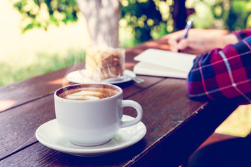 Close up cup of hot coffee on wooden table