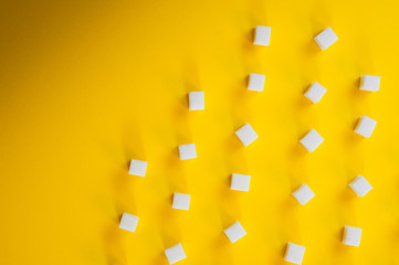 Refined sugar cubes shot on a yellow background. Background for sweets, food and drinks.