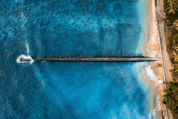 Top view of pier and sand beach with turquoise ocean water. aerial drone shot