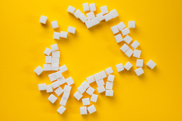 Refined sugar cubes shot on a yellow background. Background for sweets, food and drinks.
