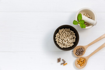 Herbal supplement in capsules with healthy medicinal plant.Alternative drug or natural pharmaceutical capsule.Medication of vitamin supplemental for care and treatment.Top view.