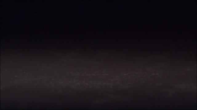 Egg falling and breaking  in slow motion on black tile surface. High speed 1600 frames per second.