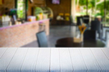 White wooden table in coffee shop blurred background.