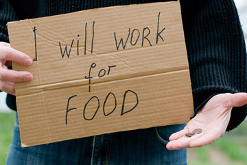 the unemployed person holds in his hand the cardboard tablet with the inscription i will work for...