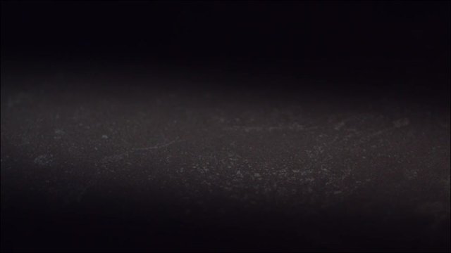 Egg falling and breaking  in slow motion on black tile surface. High speed 1600 frames per second.