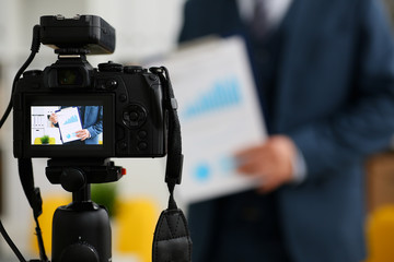 Male in suit and tie show stats graph pad making promo videoblog or photo session in office camcorder to tripod closeup. Vlogger selfie sale solution or finance advisor management information © H_Ko