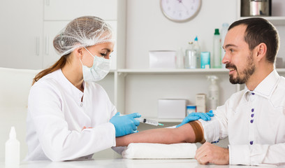 Female nurse injecting male patient