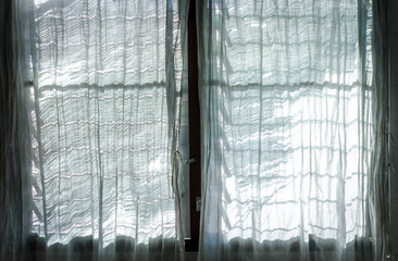 Light from the sun and shadows with window shutter and white Curtain