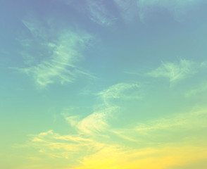 Obraz na płótnie Canvas yellow green light in light blue sky with spread clouds