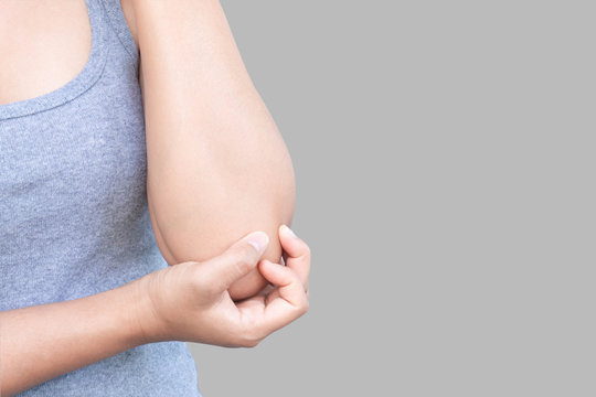 Closeup Woman Hand Holding Elbow With Pain On Grey Background, Health Care And Medical Concept