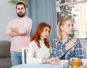 Woman having serious quarrel  with adult children in home interior
