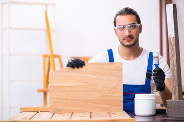 Young male contractor working in workshop