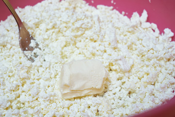 Stirring cottage cheese and butter. Cooking cake 
