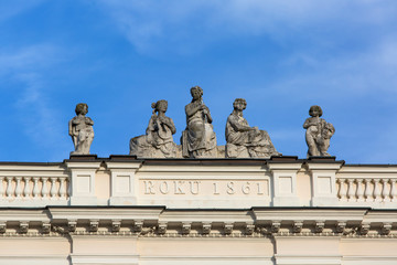 Fototapeta na wymiar Sculptures at the top of the building on the Krakowskie Przedmiescie street, Warsaw, Poland