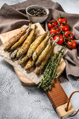 Fried smelt, sprats. Small fried fish. Gray background. Top view