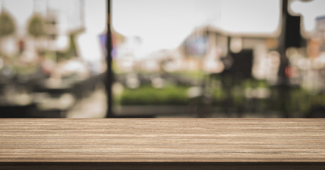Empty of wood table top with blurred coffee shop on background