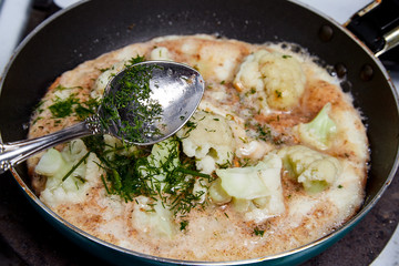 Cooking. Frying Broccoli in a pan with a liquid egg