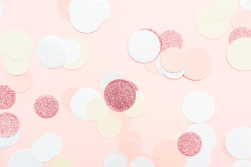 Multicolor pink, gold and white confetti on the light peach pink background, holiday celebration backdrop, Flat lay style with place for text