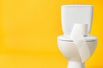 Toilet bowl with roll of paper on color background