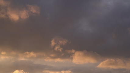 Obraz premium Beautiful evening blue sky at sunset with flaming bright light clouds. A warm summer evening at sunset.