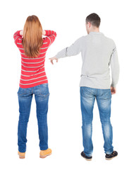 Back view of couple in sweater pointing.