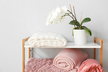 Soft warm plaid and orchid plant on shelf unit