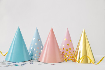 Party hats and decor on light background