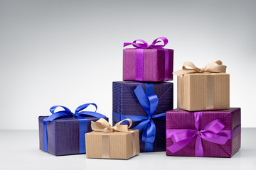Set of gift boxes on a gray background. Crafts from needlework and colored paper, decorated with...