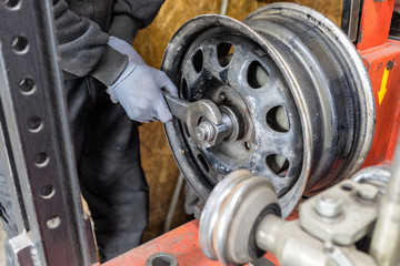 Professional worker repairs car tire