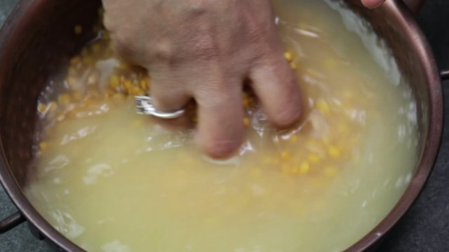 A woman washing lentils to make Daal.