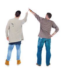 Naklejka premium Back view of two man in sweater pointing.