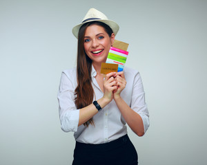 smiling woman holding credit card with passport and ticket.