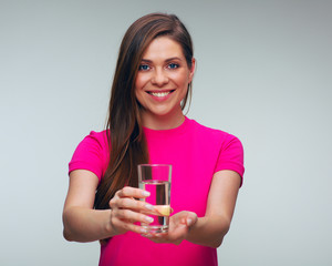 Smiling woman in red dress holding water glass in front of herself.