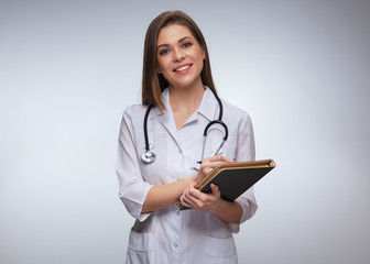 Smiling woman doctor writes in medical journal.